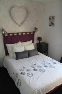 een slaapkamer met een groot wit bed met een hart aan de muur bij Maison d'hôte - Le Valdaine in Portes-en-Valdaine