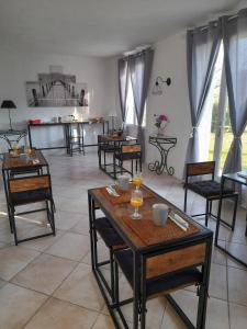 een woonkamer met tafels en stoelen en een keuken bij Maison d'hôte - Le Valdaine in Portes-en-Valdaine