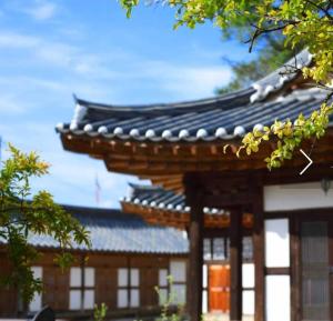 an asian building with a black roof and windows at Hanok Story in Jeonju