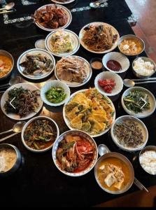 a table with many different dishes of food on it at Hanok Story in Jeonju