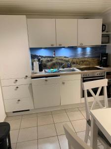 una cucina con mobili bianchi e un lavandino di Ferienanlage Kappeln-Kopperby 2 a Kopperby