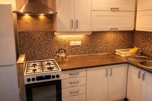 a kitchen with white cabinets and a stove top oven at Urban Nest in the city center in Poprad