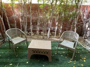 two chairs and a table in a yard at Cozy Townhouse with a Backyard in Sheikh Zayed