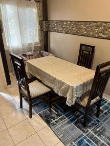 a dining table with two chairs and a table with a tablecloth at Cozy Townhouse with a Backyard in Sheikh Zayed +4 photos