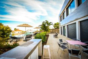 een terras met tafels en stoelen op een gebouw bij VillasRoyale Diamante in San Bartolomé