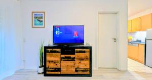 a flat screen tv sitting on a stand in a kitchen at Souterrain Casa Siegburg in Siegburg +11 photos