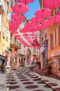 Eine Gruppe roter Regenschirme hängt über einer Straße in der Unterkunft New - Appartement ou Studio Centre Ville Confort in Grasse + 7 Fotos