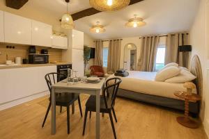 a bedroom with a bed and a table with chairs at New - Appartement ou Studio Centre Ville Confort in Grasse
