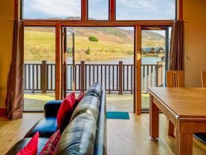 een woonkamer met een bank en een groot raam bij Fois Bhrus in White Bridge