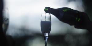 a bottle of wine is being poured into a glass at Cabane entre terre et ciel in Saint-Nicolas-la-Chapelle