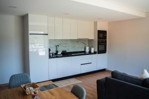 a kitchen with white cabinets and a table in a room at Chalé da Boucinha in Celorico de Basto