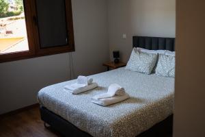 a bedroom with a bed with towels on it at Chalé da Boucinha in Celorico de Basto