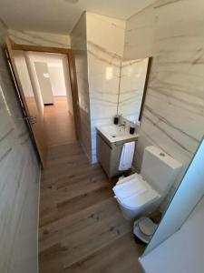 a bathroom with a toilet and a sink and a mirror at Chalé da Boucinha in Celorico de Basto