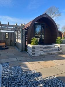a building with a arched doorway and a patio at Mill House Farm Pods- Jackdaws Den in Pilling