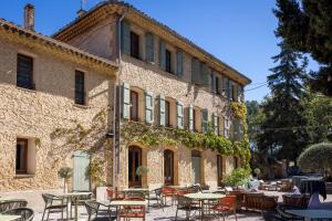 Un edificio con mesas y sillas delante. en Domaine Gao, en Aix-en-Provence