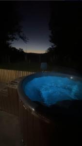 NantmelにあるGlamping Life Retreatの- 庭の青い大型ホットタブ(夜間)