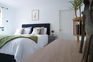 een slaapkamer met een groot bed met witte en groene lakens bij Carreg Llwyd in Caerphilly