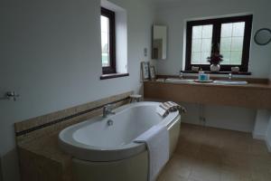 a bathroom with a bath tub and a sink at Carreg Llwyd in Caerphilly