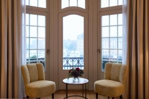 two chairs and a table in a room with windows at Hotel Diplomat Stockholm in Stockholm