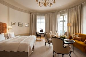a bedroom with a large bed and a living room at Hotel Diplomat Stockholm in Stockholm