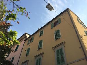 a building with green shuttered windows and a street light at Ca' Le Erbe in Fano