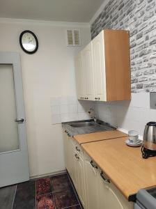 a kitchen with a counter and a clock on the wall at Laima in Riga +4 photos