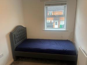 a small bed in a room with a window at Joels place in Manchester