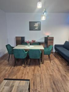 a dining room with a table and green chairs at Apartament Połczyn-Zdrój 50m2 in Połczyn-Zdrój +14 photos