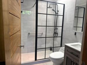 Un baño con ducha con puerta de cristal. en Hostal Mac, en Chillán 29 fotos más