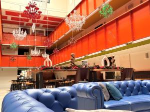 a large blue couch in a room with a restaurant at Hôtel La Fabrique in La Rochelle