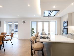 une cuisine avec une longue île dotée de chaises et d'un comptoir dans l'établissement Chancery View, à Linton