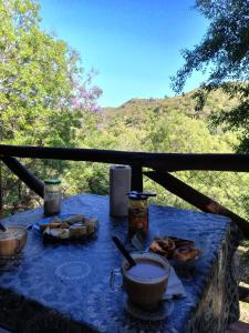 une table avec un chiffon bleu et de la nourriture dans l'établissement Cabañas de montaña "Alquimia en Las Cascadas", à La Rancherita 43 autres photos