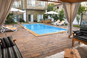 a swimming pool in a yard with chairs and umbrellas at Quiet Corner Apartment in Luxor