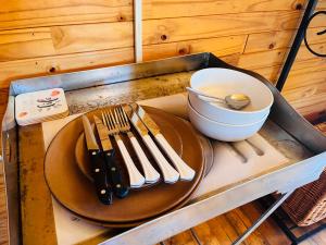 ein Tisch mit einem Teller, einer Schüssel und Besteck in der Unterkunft Lake Cabin in Olifantshoek