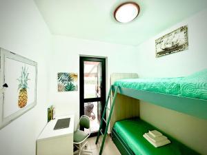 a dorm room with a bunk bed and a desk and a window at Pine Beach House - Villaggio Turistico con Piscina e Animazione in Campofelice di Roccella