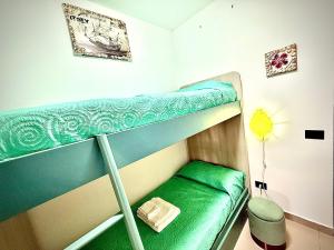 a green bunk bed in a small room at Pine Beach House - Villaggio Turistico con Piscina e Animazione in Campofelice di Roccella
