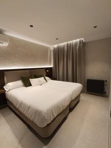Un dormitorio con una gran cama blanca en una habitación. en Amaranta Hotel Boutique, en Ronda