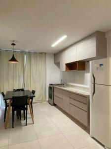 een keuken met een tafel en een witte koelkast bij Jardins Mangueiral in Brasilia
