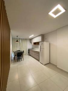 een keuken met een tafel en een witte koelkast bij Jardins Mangueiral in Brasilia