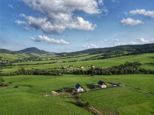 an aerial view of a green field with houses at Lackowa Chill and Rest domki z balią Krynica Zdrój in Krynica Zdrój