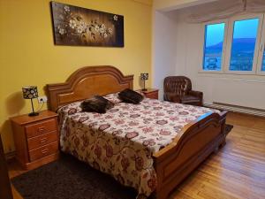 Un dormitorio con una cama y una silla y ventanas. en Torre Plaza 4, en Boiro