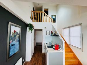 un corridoio con scala e lavandino in una casa di Appartement duplex vue mer ad Audierne Altre 12 foto