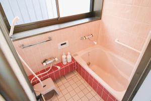 a pink bathroom with a tub and a toilet at Oharama House in Nasushiobara +25 photos