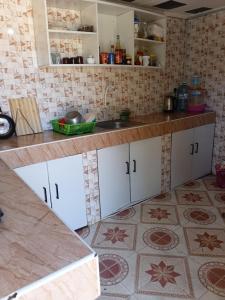 een keuken met witte kasten en een tegelvloer bij Amatamata in Malindi