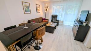 a living room with a couch and a table and a television at Souterrain Casa Siegburg in Siegburg
