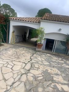 une maison avec un patio en pierre devant dans l'établissement Studio indépendant chez Pascale, à Saint-Clément-de-Rivière