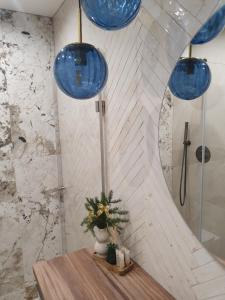 een badkamer met blauwe glazen hanglampen en een tafel bij Apartament Łynova z parkingiem podziemnym in Olsztyn +26 foto's
