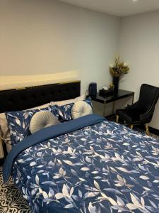 een slaapkamer met een bed met een blauw dekbed bij Marble Black Deluxe in Gloucestershire +1 foto