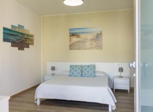 een slaapkamer met een bed en een schilderij aan de muur bij Affittacamere Lumal in Domus de Maria