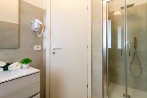 een douche met een glazen deur in een badkamer bij Affittacamere Lumal in Domus de Maria